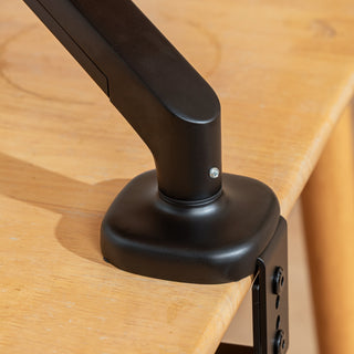 Close-up of the clamp base and black arm of the Catomi desk cat bed on a wooden desk edge
