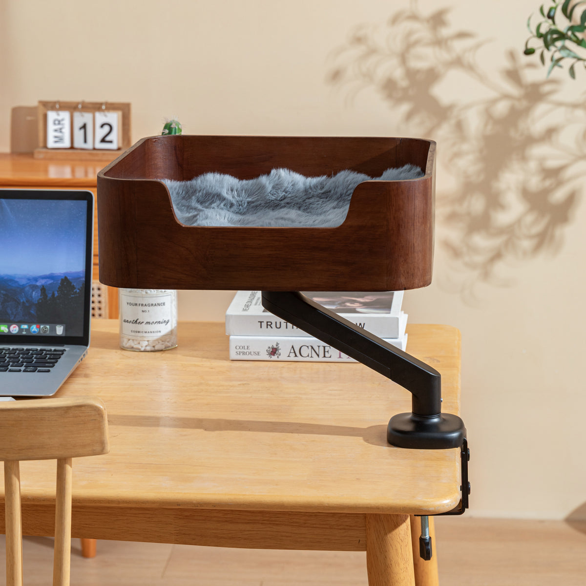Catomi desk cat bed in Walnut clamped to a desk, with a grey cushion and books below